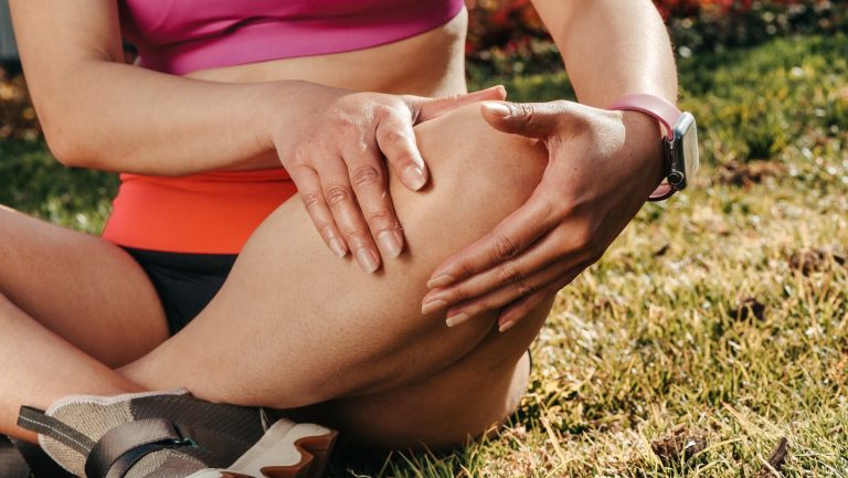 close up of woman sitting while holding knees